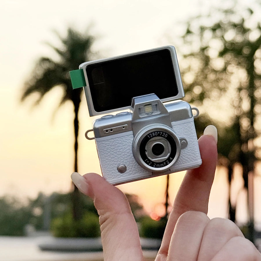 Flip Digicam held up at sunset with its screen flipped open