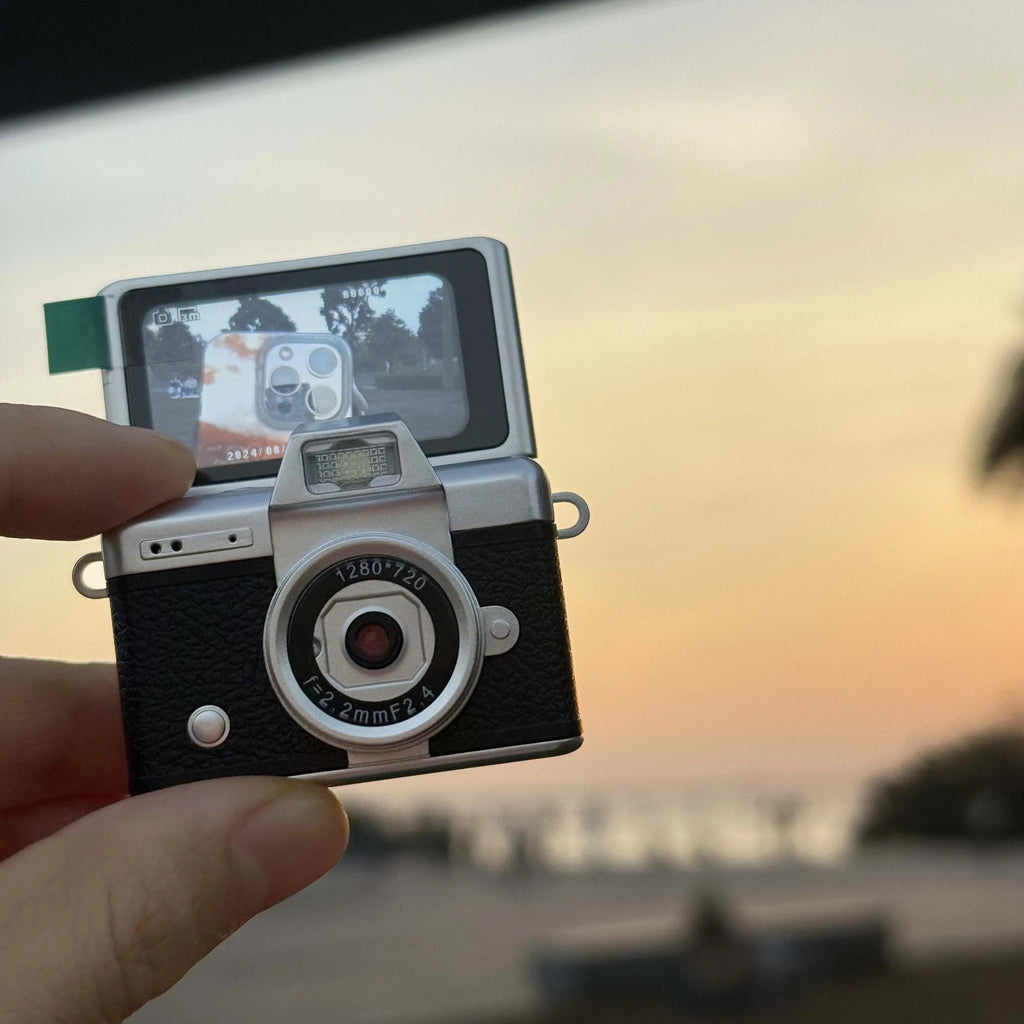 Black Flip Digicam in hand with the flip screen showing a live view